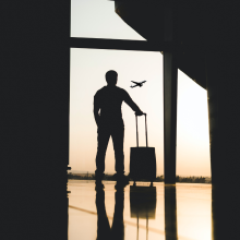 Mężczyzna z walizką stojący na terminalu lotniczym